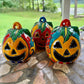 Three colorful hand-painted Talavera jack-o'-lantern pumpkins with multi-color displayed on a stone patio with a blurred green lawn background.