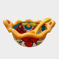 Colorful talavera salsa bowl with floral patterns and spoon on a white background Front view