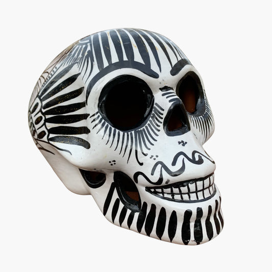Black and white Mexican Sugar skull with vibrant designs on a white background