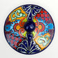Mexican covered tortilla serving piece with blue rim and multi-color designs, top view with cover on.
