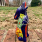 Colorful Talavera Coyote figurine on a brick surface with a grassy area in the background