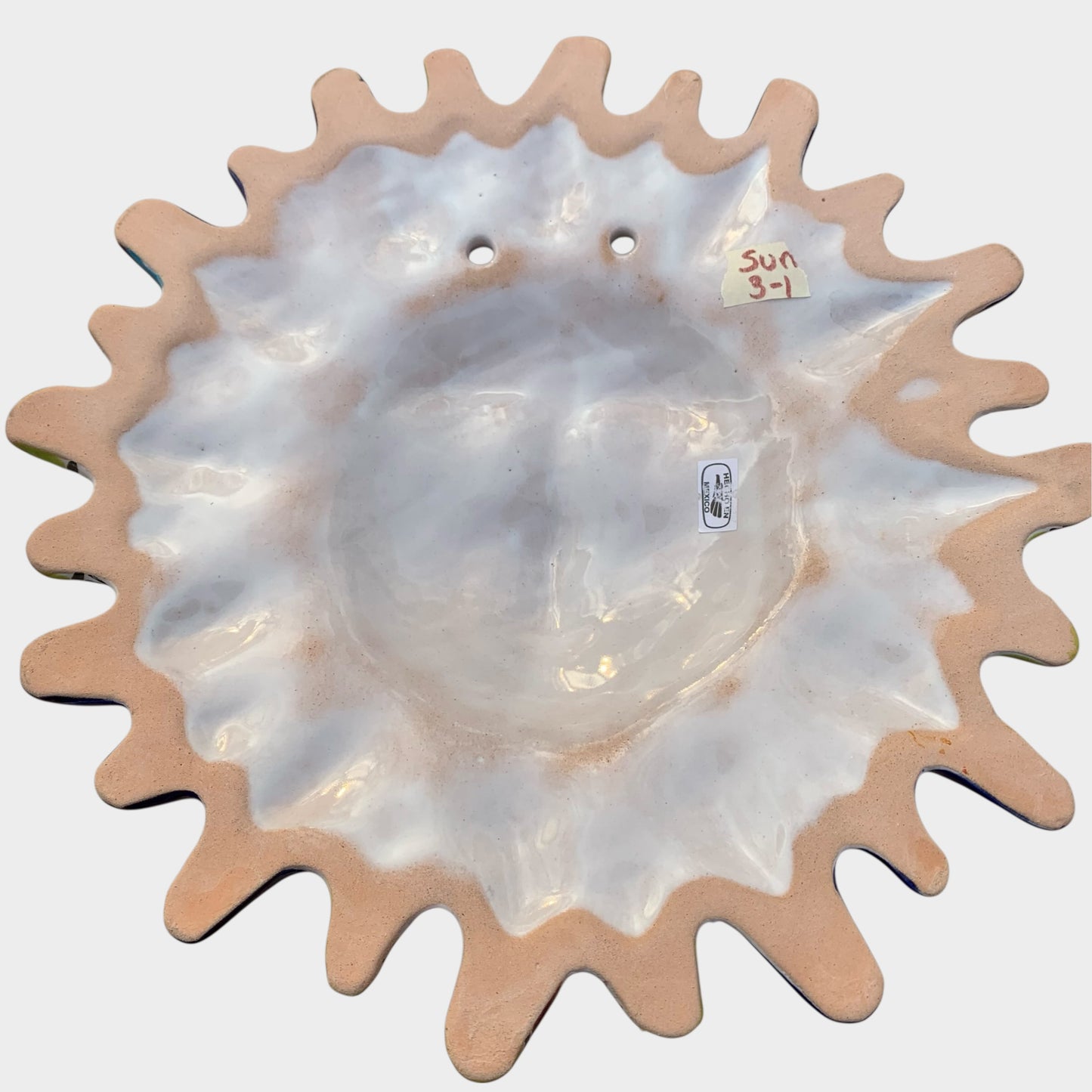 Decorative Talavera sun-shaped wall art with colorful face design on a white background Back view