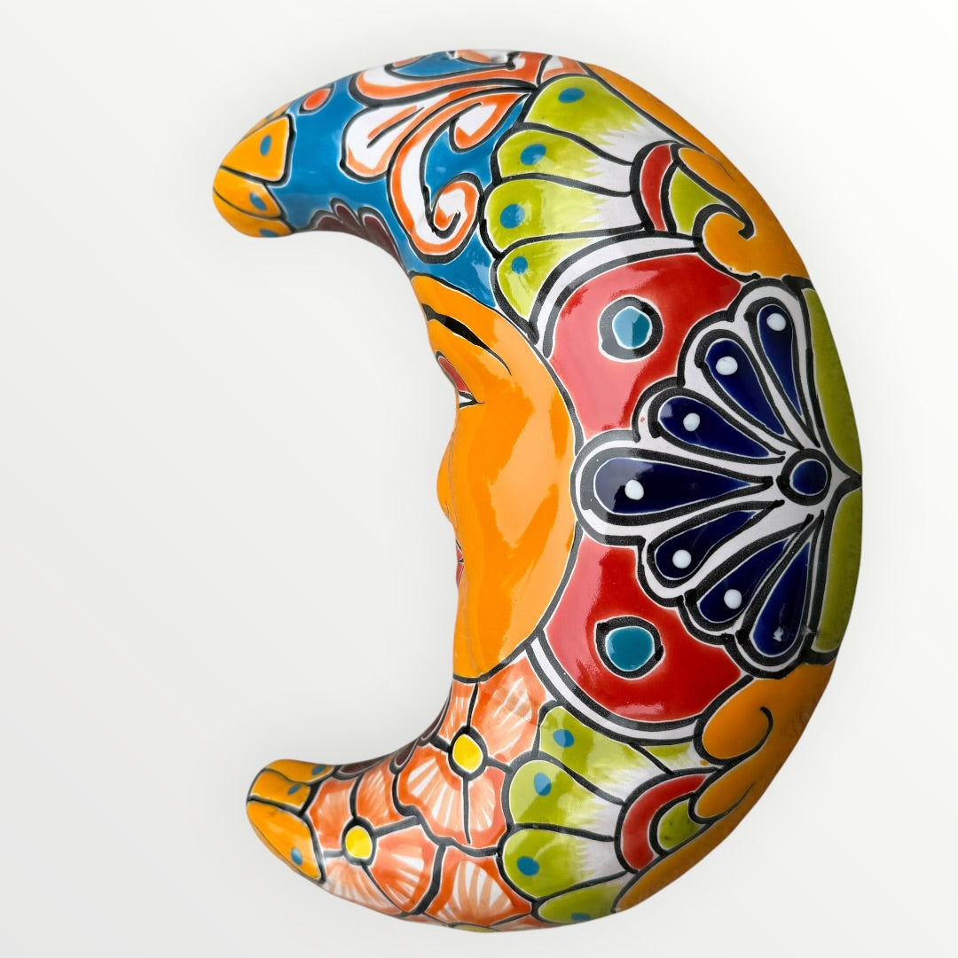 Decorative ceramic crescent moon with colorful patterns on a white background curved side