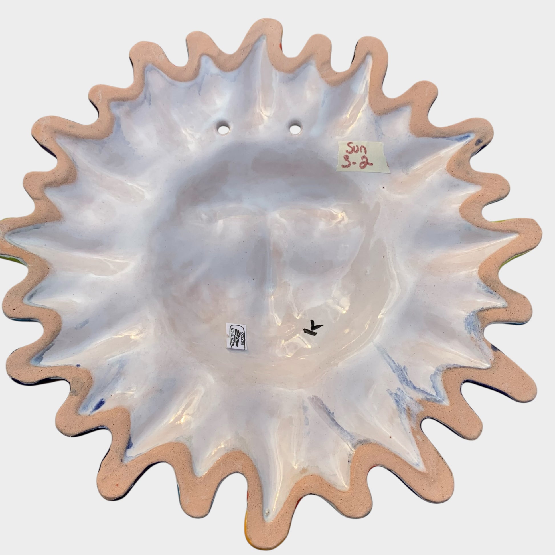 Decorative Talavera sun-shaped wall art with colorful face design on a white background Back view 