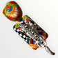 A talavera catrina dog skeleton figurine with colorful hand-painted floral and geometric patterns, standing on a matching decorated base against a plain white background. Top view of catrina dog.