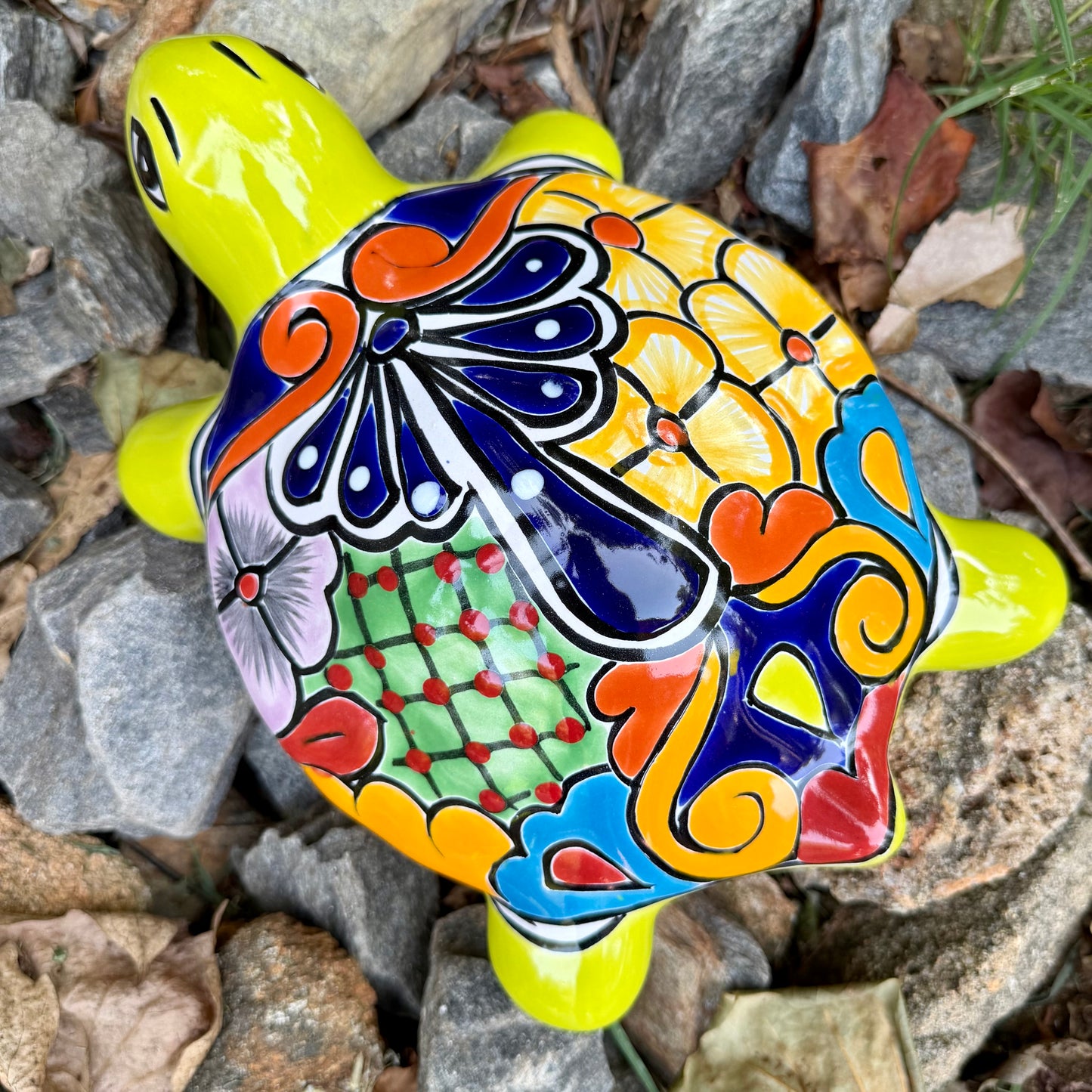 Mexican Talavera Colorful turtle-shaped object on a rocky surface Top view