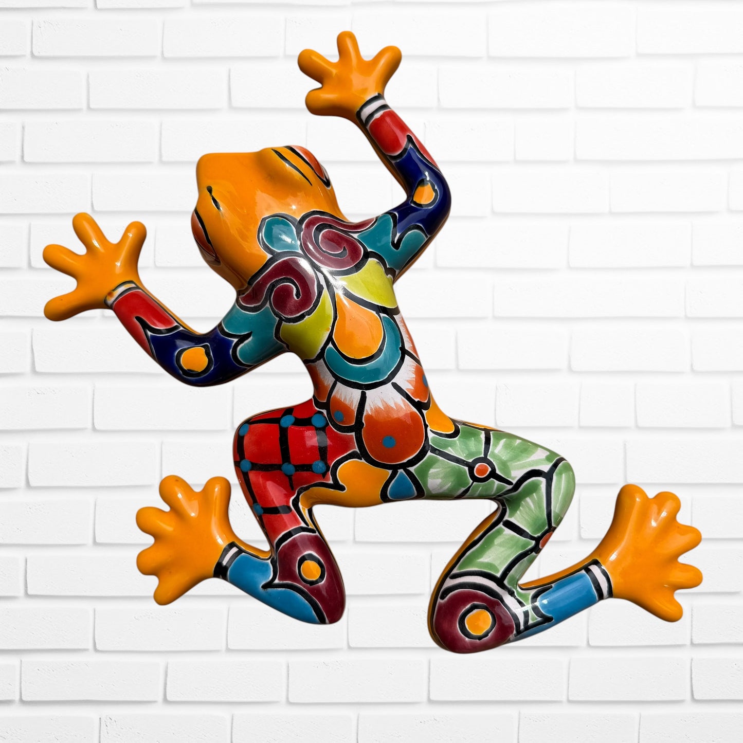 A talavera wall frog in yellow with multicolor designs on the body.