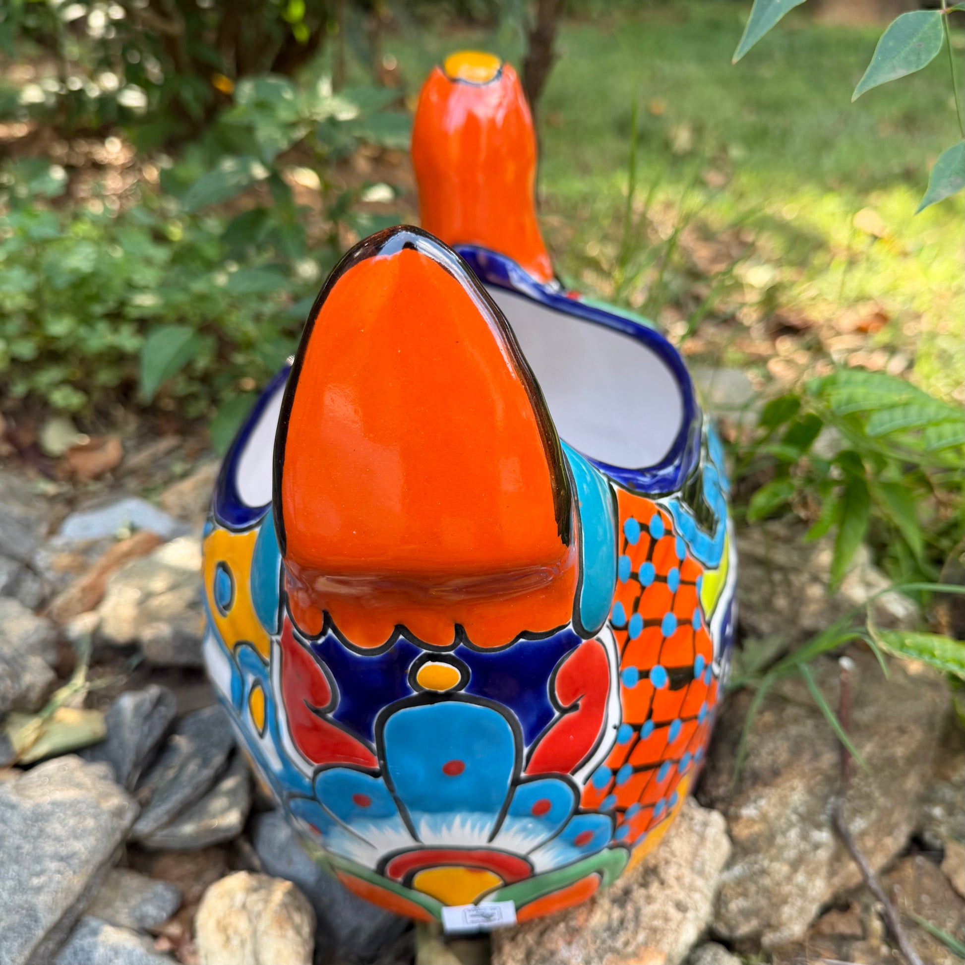 Colorful orange multi-color Mexican Talavera ceramic chicken shape planter on a natural background Back side