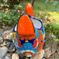 Colorful orange multi-color Mexican Talavera ceramic chicken shape planter on a natural background Back side