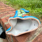 Coyote figurine on a brick surface with a garden background Bottom