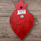 A Mexican Milagros medium heart in red with a gold and red flaming top, covered in antiqued golden charms, back view of heart with hanging hole.