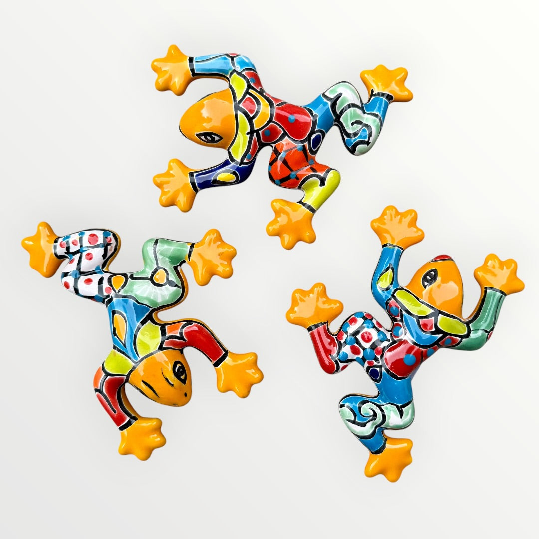 Three colorful ceramic frogs on a white background