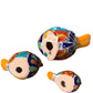 Three hand-painted ceramic bird figurines in yellow, decorated with intricate blue, black, red, green, and orange floral patterns, arranged on a rustic wooden surface bottom view.