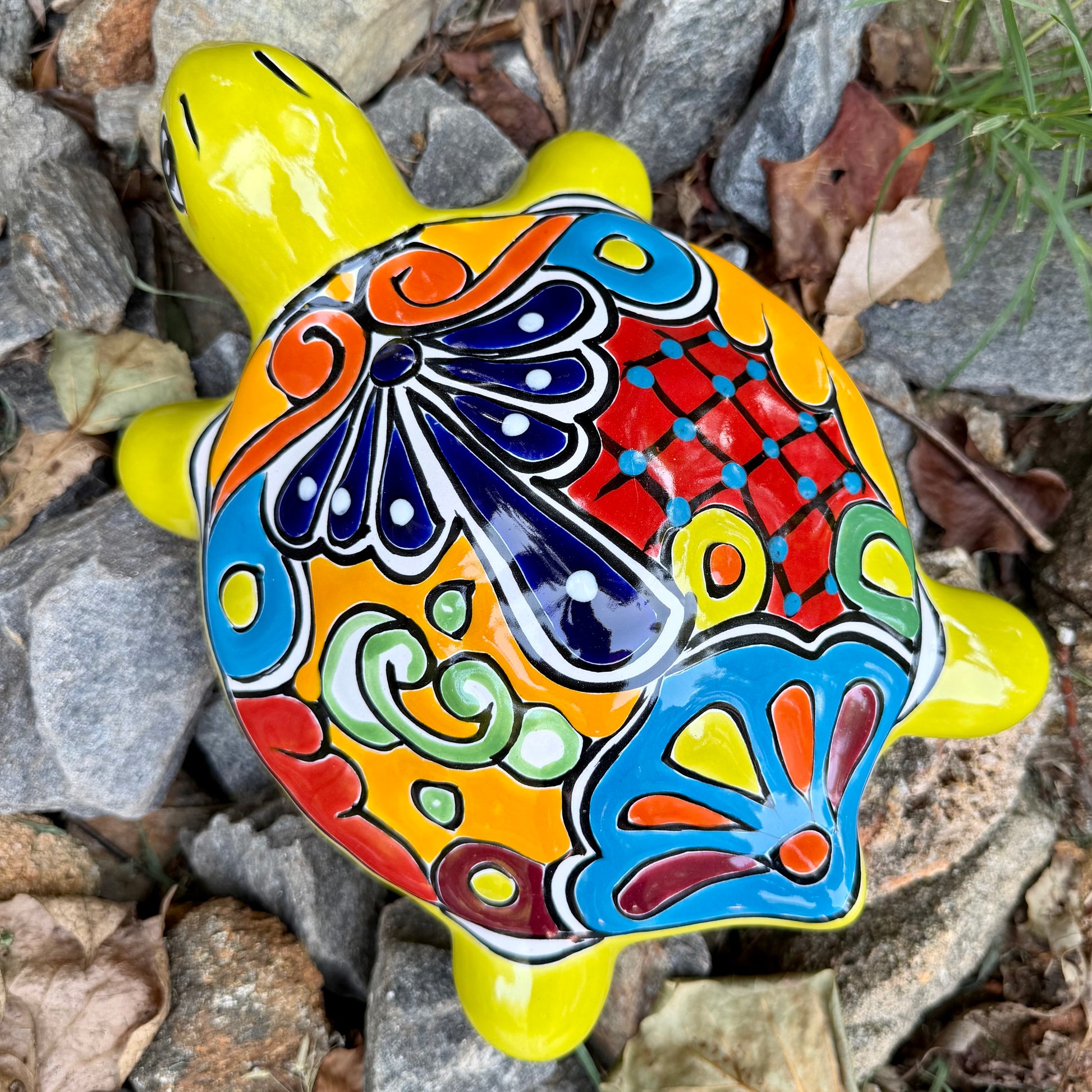 Colorful Mexican Talavera ceramic turtle figurine on a natural stone background Top