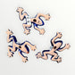 Three colorful ceramic frogs on a white background Back view