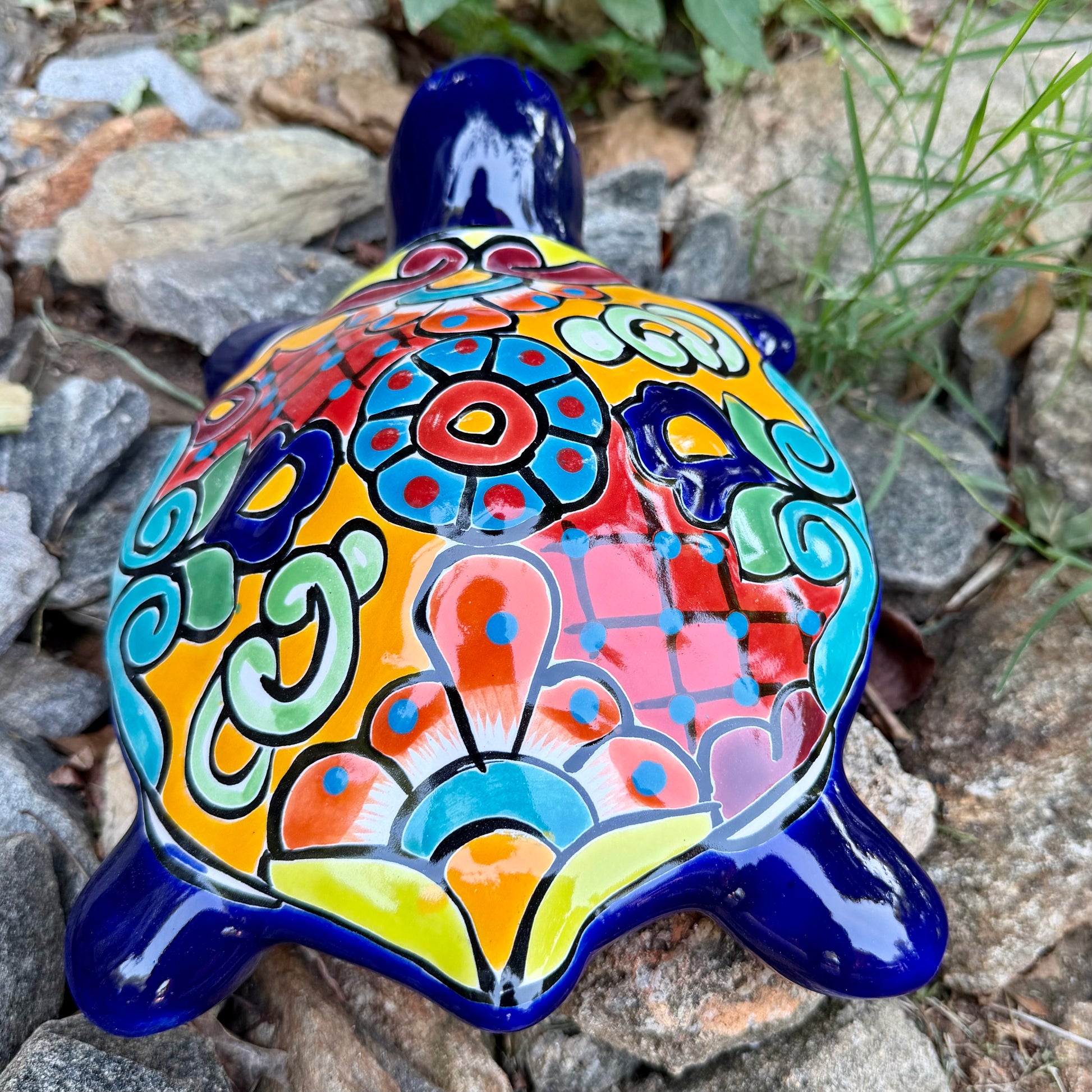 Colorful Mexican Talavera ceramic turtle figurine on a natural stone background Back