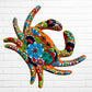 A colorful multicolor hand-painted wall art sculpture of a crab, decorated with vibrant floral patterns, shown against a white brick wall background.