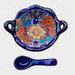 Colorful talavera salsa bowl with floral patterns and spoon on a white background