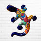 Colorful ceramic lizard wall art against a white brick wall background