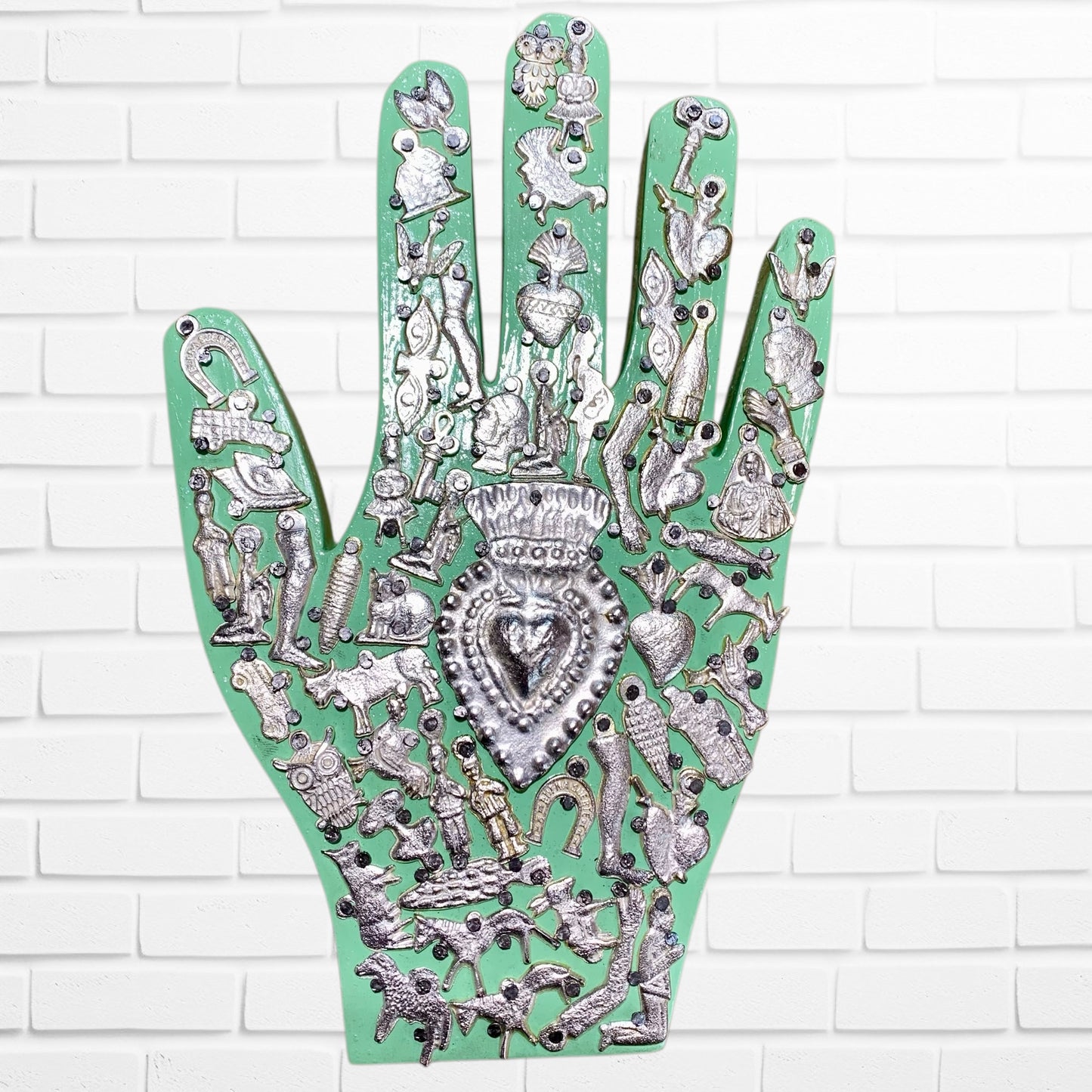 Decorative palm with intricate silver designs on a green background light green