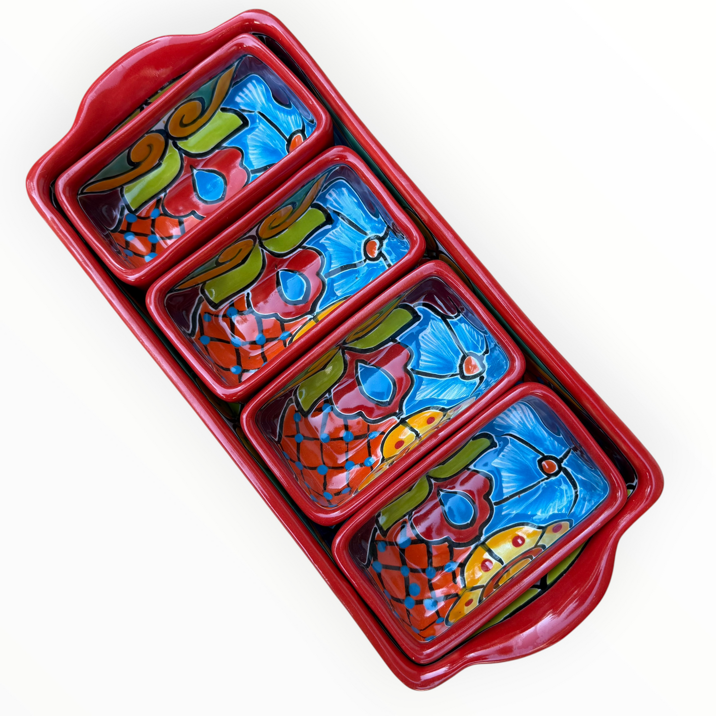 A red ceramic four-compartment serving tray with hand-painted talavera designs in blue, orange, green, and yellow on a white background.