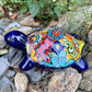 Colorful Mexican Talavera ceramic turtle figurine on a natural stone background Right side