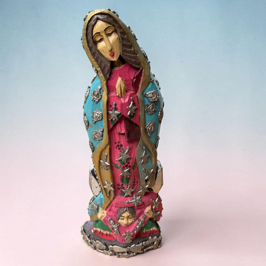 Wooden milagros virgin guadalupe with child wearing a pink gown and a blue robe with stars and roses charms adorning her clothing, a child is at her feet. 