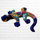 Colorful lizard-shaped object against a white brick wall background side