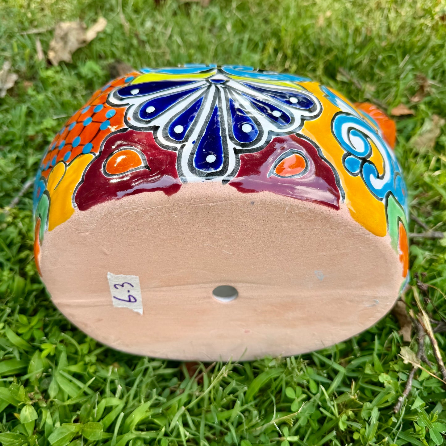 Colorful orange multi-color Mexican Talavera ceramic chicken shape planter on a natural background Bottom drain hole