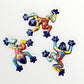 Three colorful ceramic frogs on a white background