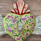 Milagros decorated sacred heart with wings center with milagros charm