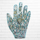 Decorative hand-shaped wall art with various embellishments on a white brick wall background light blue one