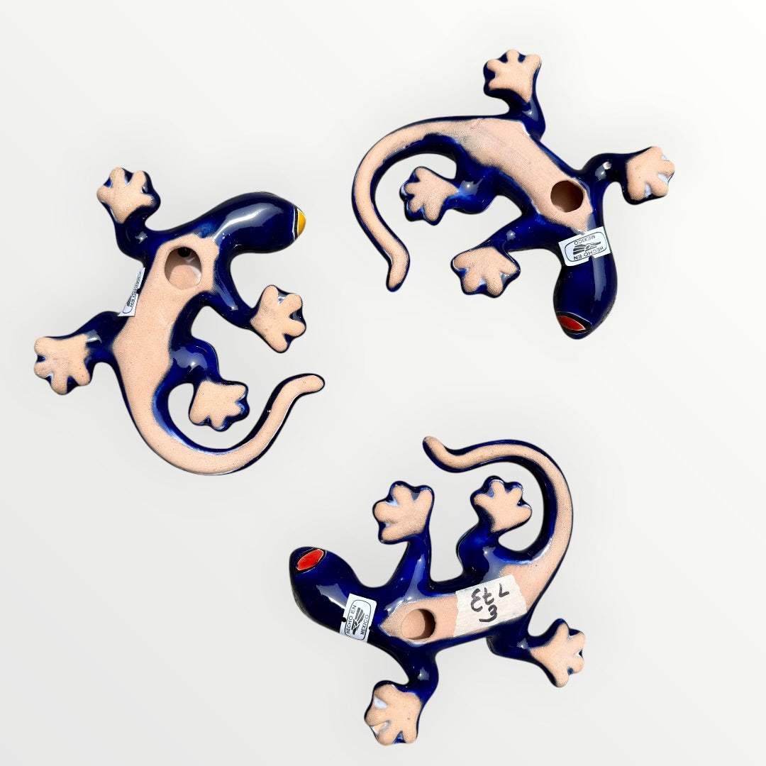 Three colorful Talavera ceramic lizards on a white background Back view