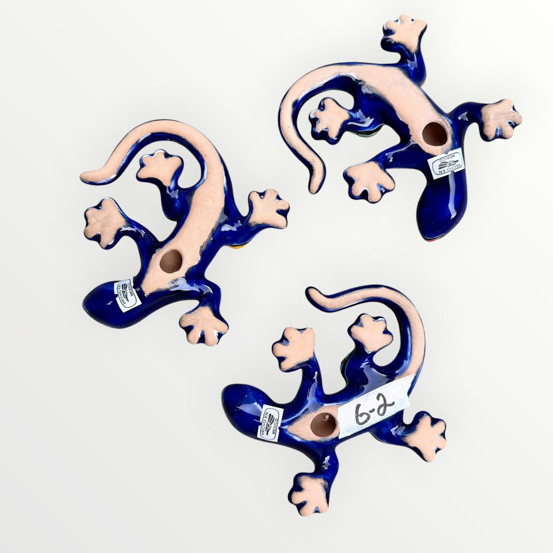 Three colorful ceramic lizards on a white background Back
