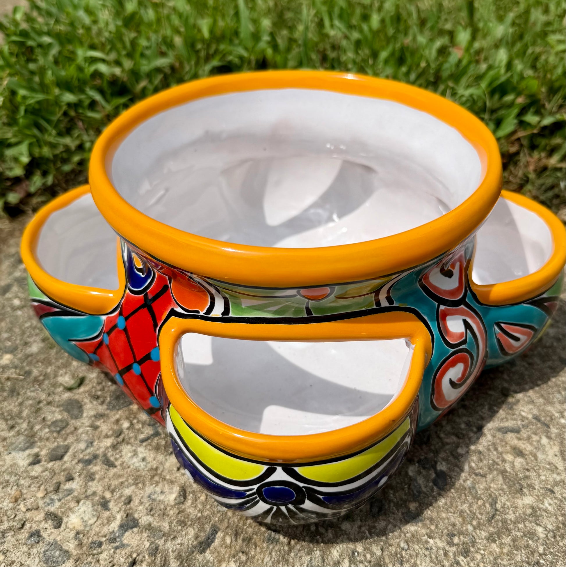 Hand painted Mexican Talavera Strawberry pot with a large top opening a four pockets on each side.  Trim color is bright happy yellow, body has multi-color designs on each of the four sides.