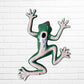A colorful hand-painted ceramic frog wall sculpture in a dynamic jumping pose, decorated with vibrant green, red, orange, yellow, and blue patterns, set against a white brick wall background back. 