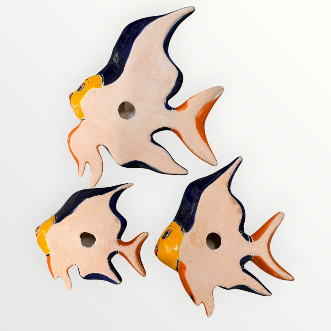 Three fish-shaped ceramic decorations on a white background back view