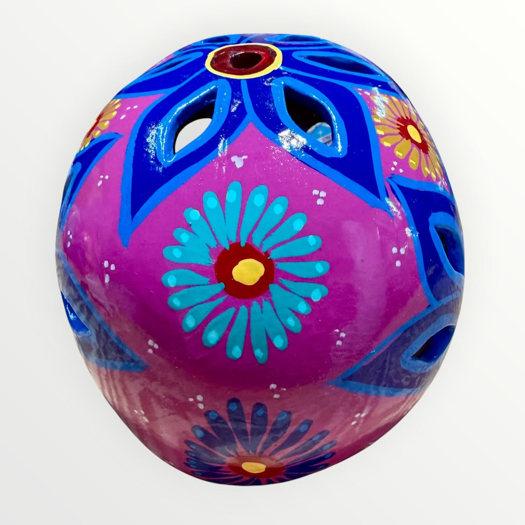 A hand-painted ceramic sugar skull mask in vibrant magenta pink, decorated with colorful floral and geometric patterns in blue, yellow, red, and white, set against a plain white background back skull view.