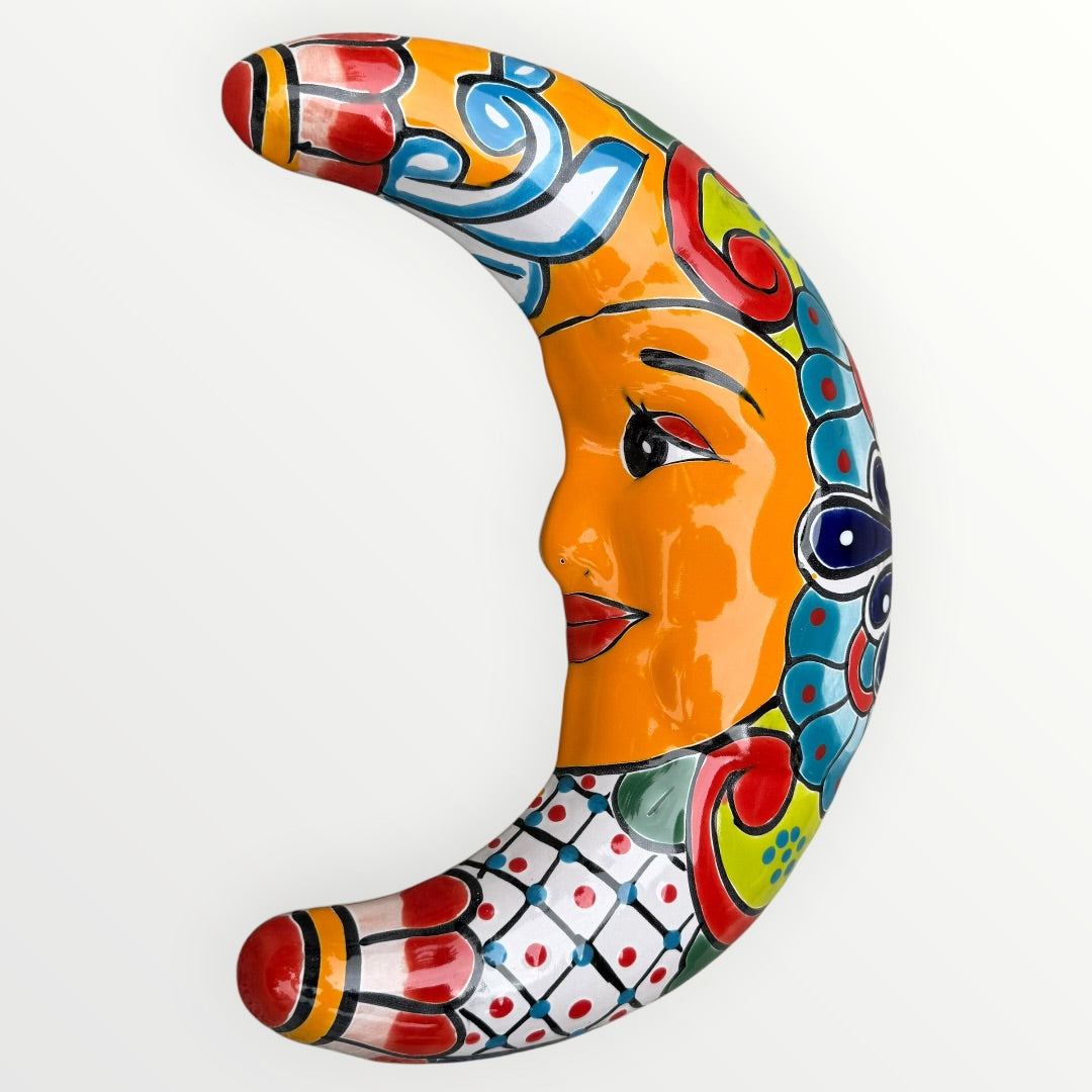 Colorful ceramic crescent moon with face design on a white background face view