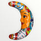 Colorful ceramic crescent moon with face design on a white background face view