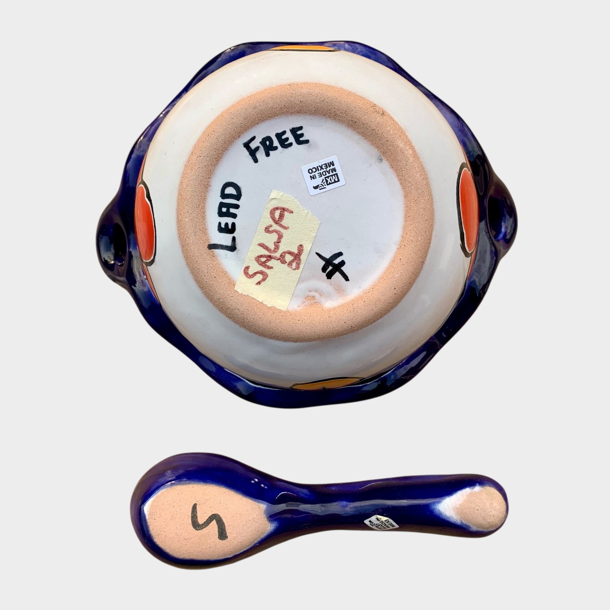 Colorful talavera salsa bowl with floral patterns and spoon on a white background Bottom