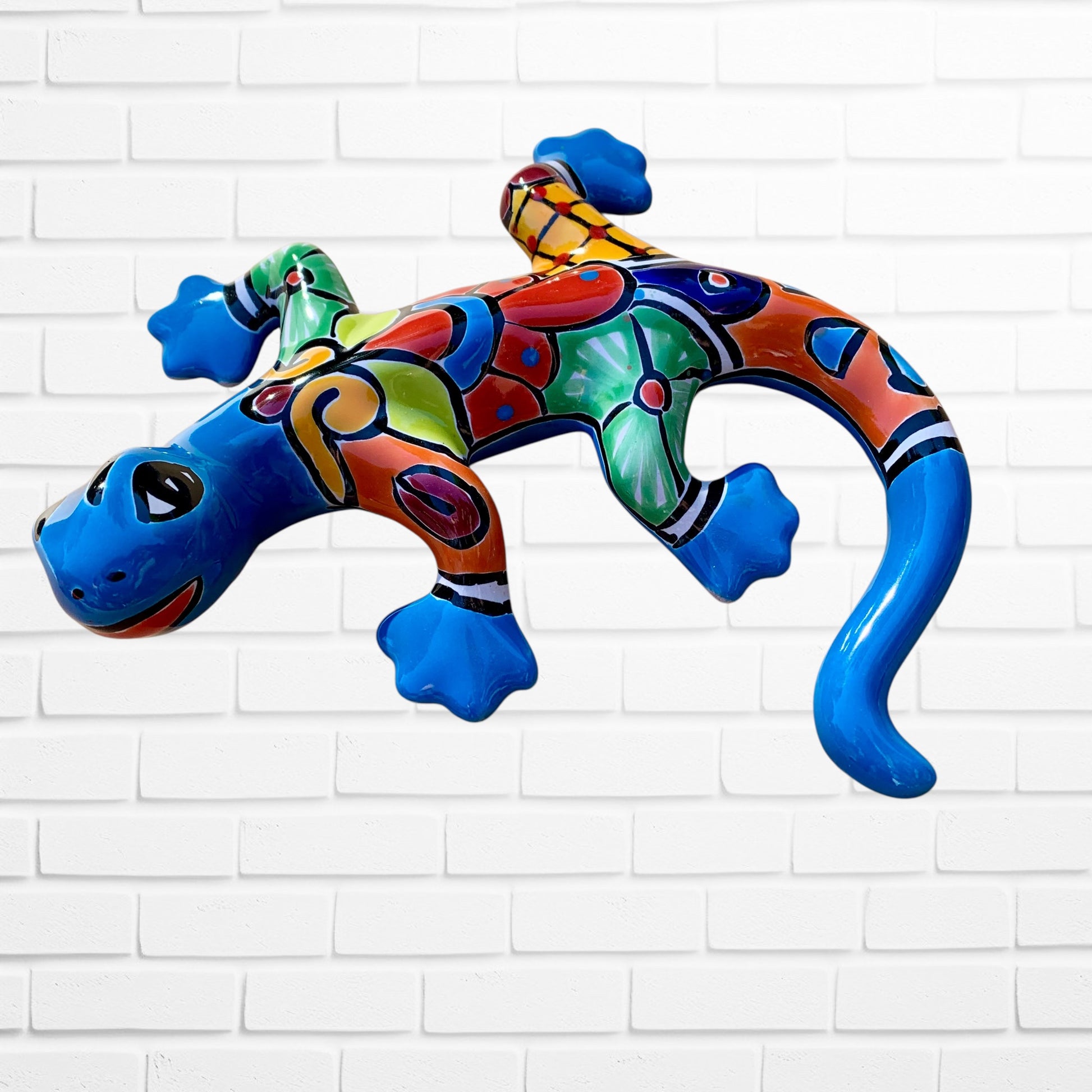 Colorful ceramic lizard wall art on a white brick wall background side