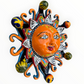 A colorful hand-painted Talavera ceramic sun wall decor piece with a smiling face, orange center, planets, and multicolored rays on a plain white background left side view three dimensional.