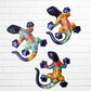 Three colorful ceramic gecko wall art pieces in a vibrant multicolor design, displayed against a white painted brick wall.
