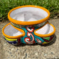 Hand painted Mexican Talavera Strawberry pot with a large top opening a four pockets on each side.  Trim color is bright happy yellow, body has multi-color designs on each of the four sides. Photo of the side.