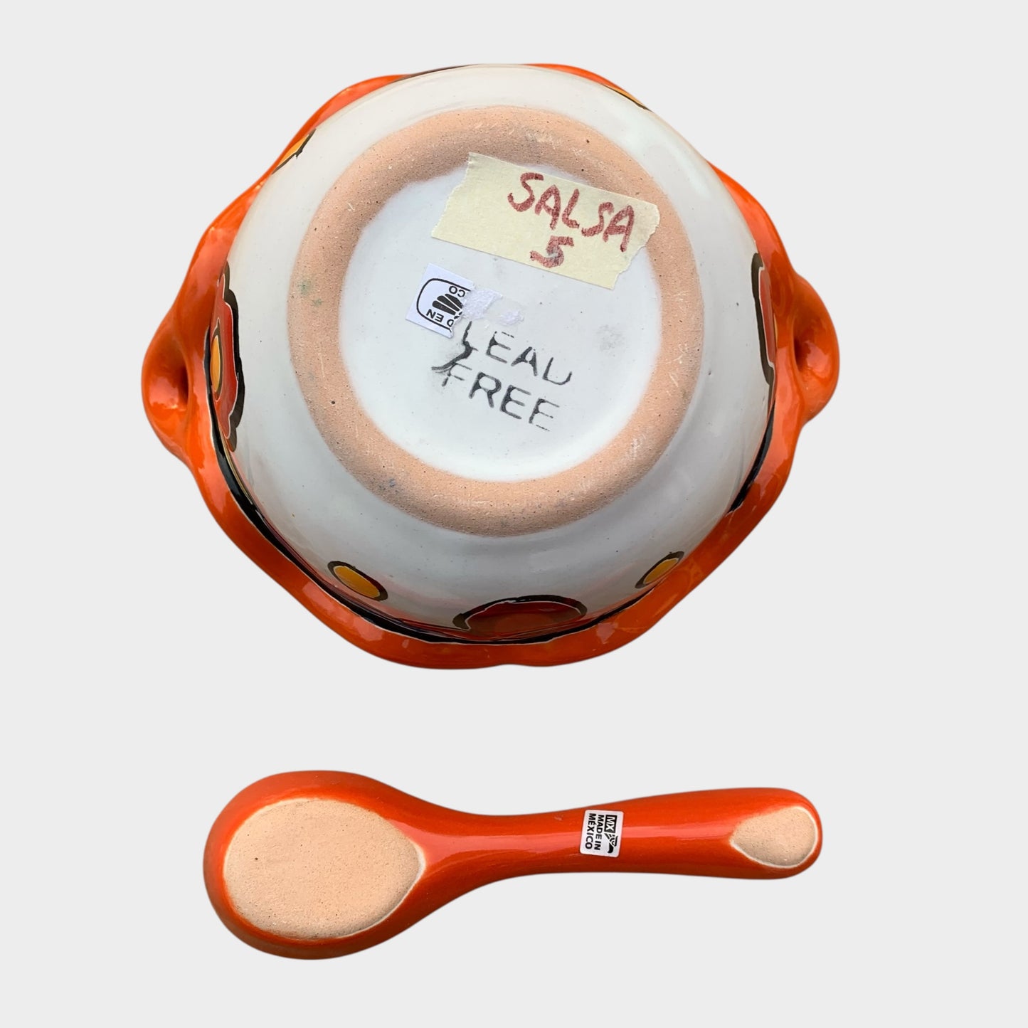 Colorful talavera salsa bowl with floral patterns and spoon on a white background Bottom