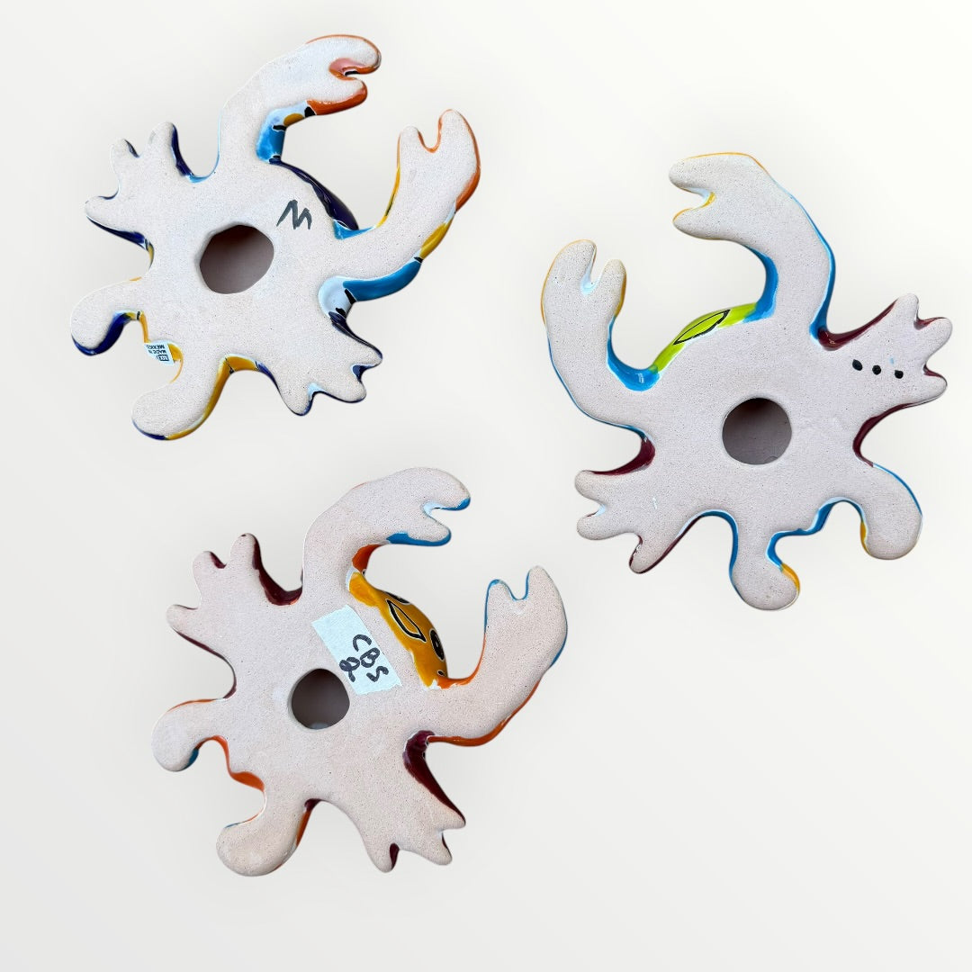Three colorful hand-painted ceramic crabs back view showing hanging hole.