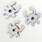 Three colorful hand-painted ceramic crabs back view showing hanging hole.