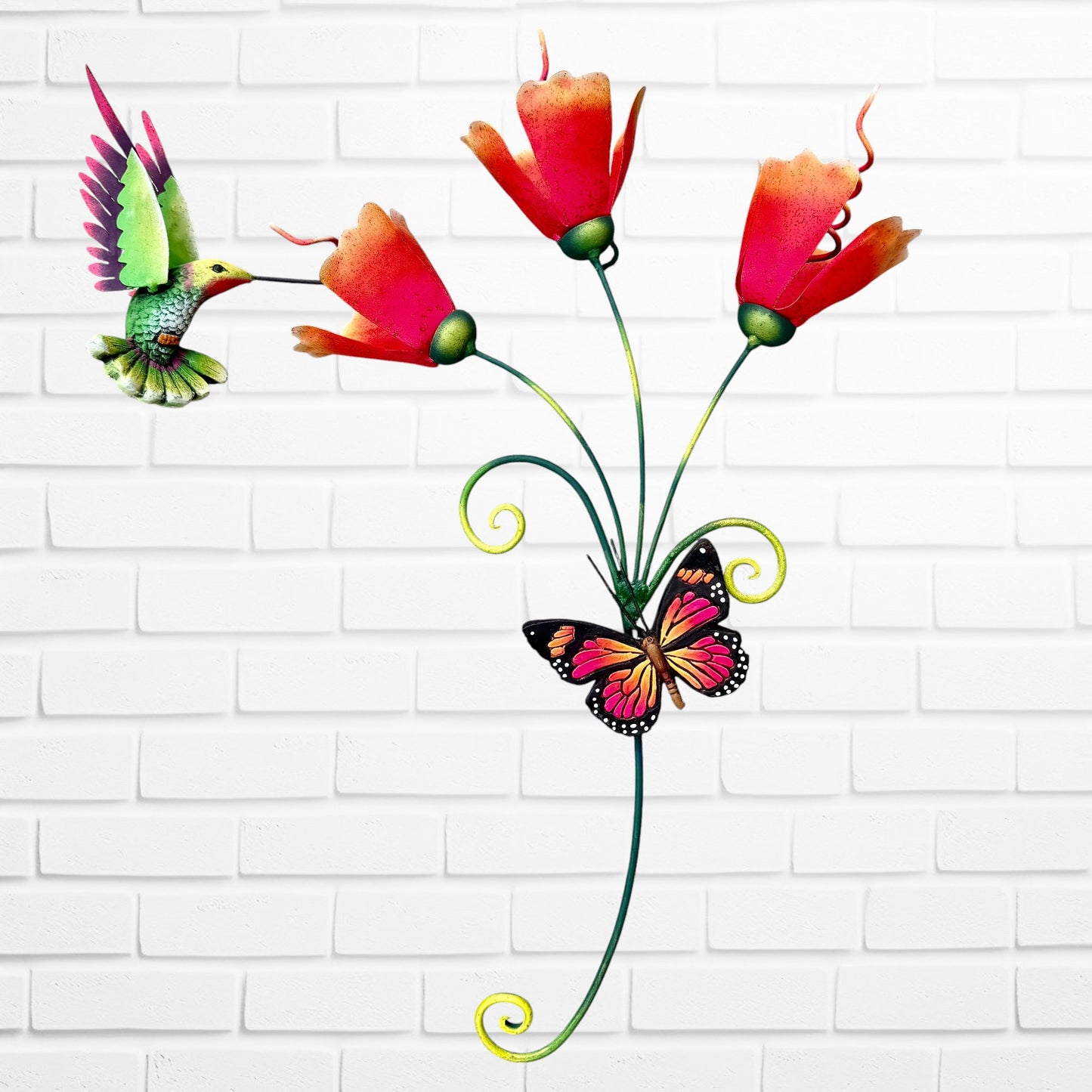 Decorative wall art with orange flowers, hummingbird, and a butterfly on a white brick wall background.