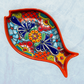 Red fish-shaped Talavera  serving dishes with colorful hand-painted floral and geometric patterns, displayed on a light blue textured background.